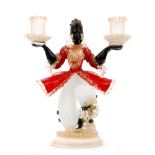 A post war Murano candelabra modelled as a blackamoor in a red frill jacket with applied detail