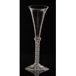 An 18th Century drinking glass circa 1760 with a drawn trumpet bowl above three basal collars and a