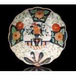 An early 19th Century scallop edge shallow dish decorated with a central vase of flowers with a