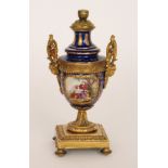 An early 20th Century pedestal vase with affixed cover,