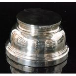 An Art Deco hallmarked silver circular ink well of plain stepped from, terminating in plain cover,