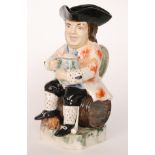 A Peggy Davies ceramic sculpture model of a Toby jug with a figure sat on a barrel,