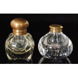 Two early 20th Century brass and clear glass ink wells,