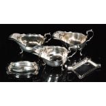 Three hallmarked silver sauce boats each with cut edge border decoration and raised on three