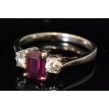 A ruby and diamond three stone ring, two brilliant cut diamonds beside central emerald cut ruby,