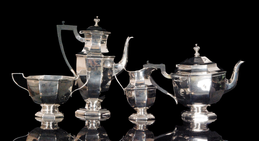 A hallmarked silver four piece tea service composed of teapot, twin handled sugar bowl,