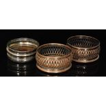 A pair of 19th Century silver plated on copper bottle coasters with pierced borders, diameter 13cm,