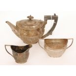 A hallmarked silver bachelors three piece boat shaped teaset of part fluted form, total weight 12.