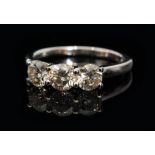 A modern 18ct white gold three stone diamond ring,