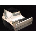 A hallmarked silver elongated square ink well of plain form with pen rest below square hinged cover,