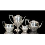 A hallmarked silver three piece tea service of part fluted boat shaped form,