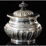 A hallmarked silver tea caddy of oval form with part fluted border and hinged cover, weight 3.