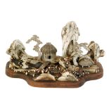 A 20th Century Chinese carved antler diorama in the form of a village scene on a hardwood base,