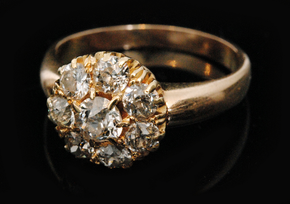 An early 20th Century 18ct diamond daisy cluster comprising eight old cut claw set stones,