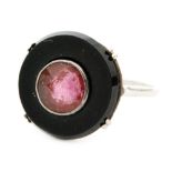 An Art Deco style target ring with claw set black onyx circle inset with pink facet cut stone to