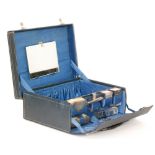 An early 20th Century blue leather travelling dressing case with outer case,