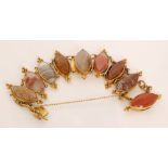A gilt metal bracelet formed of nine navette shaped panels inset with banded agate and carnelian,