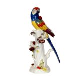 An early 20th Century Meissen model of a parrot perched on a tree branch with cherries and