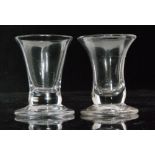 A near pair of early 19th Century drinking glasses with drawn trumpet bowl above a solid basal