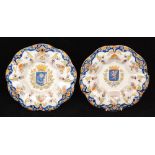 A pair of early 20th Century French faience armorial plates each decorated with a central crest