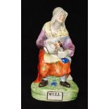 A 19th Century Staffordshire pearl ware figure of Nell, she sat on a stool with a cat beneath,