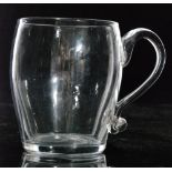 An 18th Century glass tankard of barrel form with an applied loop handle with scroll kick,