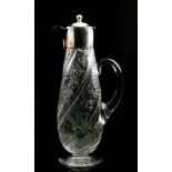 An early 20th Century Stevens & Williams clear crystal claret jug of wrythen fluted tapered ovoid