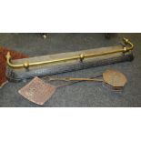 A Victorian brass rail top iron fender, together with a chestnut roaster and a milk skimmer.