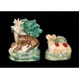 A late 18th Century Staffordshire model of stag sat on a naturalistic base and before a bocage,