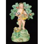 A 19th Century Walton modelled of a cherub stood before a flowering bocage holding a basket of