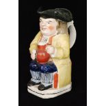 A 19th Century Staffordshire Ordinary Toby dressed in a yellow overcoat,