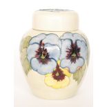 A Moorcroft Pottery ginger jar and cover decorated in the Pansy pattern with a wide band of flowers