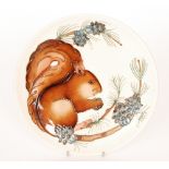 A Moorcroft Pottery 1995 cabinet plate decorated with a tubelined squirrel perched on a branch,