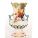 A small Hadley's Worcester twin handled footed vase decorated with hand painted autumnal fruits and