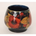 William Moorcroft - A footed spill vase decorated in the Pomegranate pattern with a band of open