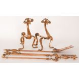 Unknown - A pair of copper fire dogs with stylised scale decorated scroll legs and pad feet below