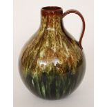Christopher Dresser - Linthorpe Pottery - A shape 877 bulbous jug decorated in a streaked green and