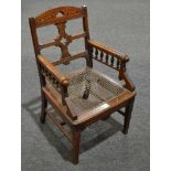 Unknown - An early 20th Century Aesthetic mahogany armchair with pierced cruciform splat back,