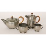 Tudric Pewter - A four piece tea set with beaten decoration to whole, pots with wicker bound handle,