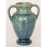 Pierrefonds - An early 20th Century twin handled vase of footed baluster form,