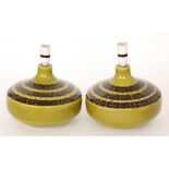 Honiton - A pair of post war lamp bases each of compressed form glazed in an olive green with brown