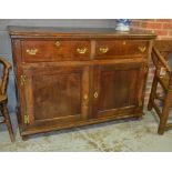 An oak two drawer cupboard brass drop handles on stiles,