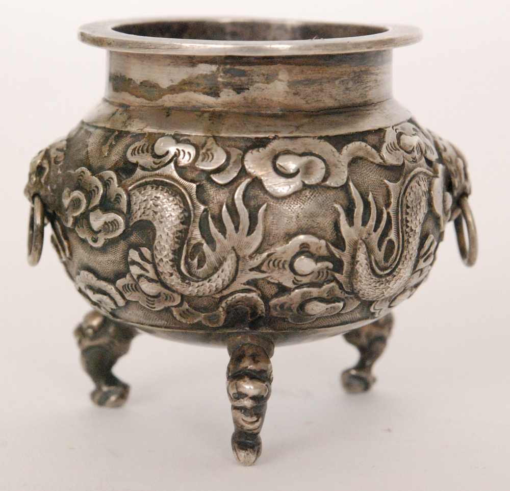 A late 19th Century Chinese silver salt of cauldron form with baluster body on three dragon feet