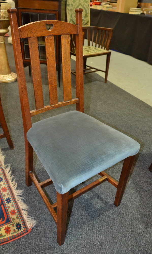 A set of seven Art Nouveau style oak dining chairs with padded seats on tapering legs (7)