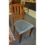 A set of seven Art Nouveau style oak dining chairs with padded seats on tapering legs (7)