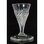 An 18th Century Flammiform dram glass circa 1750, the wrythen fluted bowl above a conical foot,