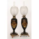 A pair of late 19th Century French black glass oil lamps each raised on three gilt metal paw feet