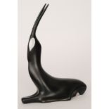 A Royal Dux boxed model of a stylised seated gazelle with elongated horns in black with white eyes,