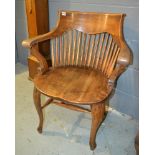 A pair of early 20th Century oak lath back elbow chairs with solid saddle shaped seats above