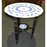 A late 19th Century occasional table with blue ceramic swivel top on ebonised legs,